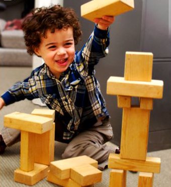 Photo of young boy building a tower of blocks.